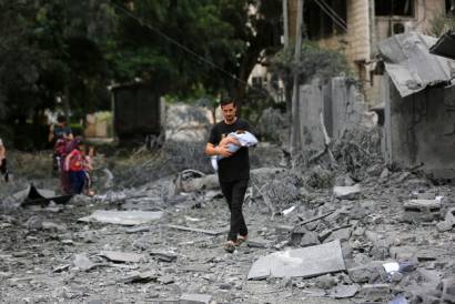 Un joven palestino camina entre escombros frente a edificios gravemente danŢados tras los ataques aeěreos israeliěes sobre la ciudad de Gaza 1